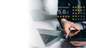A person is holding their laptop and typing.
